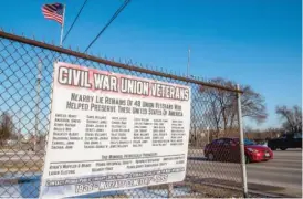  ?? MATT DAYHOFF/PEORIA JOURNAL STAR ?? A sign lists names of the 48 Civil War veterans believed to be buried under the pavement in the area around 3915 SW Adams in Peoria that used to be Moffatt Cemetery. Nance Legins-Costley is also believed to be buried there.