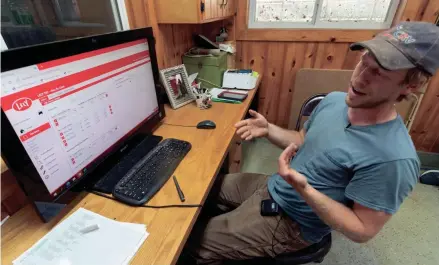  ?? MARK HOFFMAN/MILWAUKEE JOURNAL SENTINEL ?? Max Malm monitors the dashboard for the robotics his farm uses to feed and milk their dairy herd on Aug. 13 at Malm’s Rolling Acres Farm in Loyal. It was the first farm in Wisconsin to operate a Lely Vector automatic feeding system, which was installed in December 2017. The Vector feed system works 24 hours a day, measuring and mixing rations for the different groups of cows on the farm. For about eight years the farm has used a pair of Lely Astronaut milking robots.