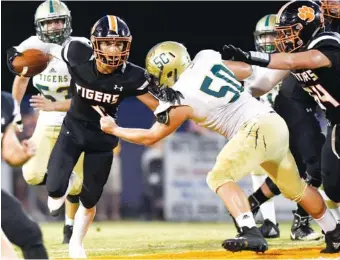  ??  ?? Meigs County’s Gabriel Maldonado breaks the tackle of Rockwood’s Jonathan Gann.