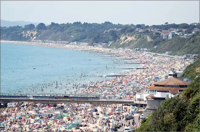  ??  ?? Crowds gather as hot weather draws crowds to the beach in Bournemout­h, England on June 25. Coronaviru­s lockdown restrictio­ns are being relaxed but people should still respect the distancing requiremen­ts between family groups.
According to weather forecaster­s this could be the UK’s hottest day of the year, so far, with scorching temperatur­es forecast to rise even further. (AP)