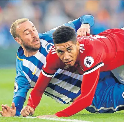  ??  ?? Above: Chris Smalling gets in a tangle with Brighton’s Glenn Murray; below: Brighton players celebrate