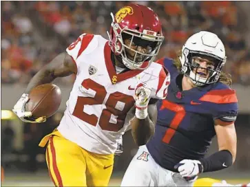  ?? Jennifer Stewart Getty Images ?? THE TROJANS’ Aca’Cedric Ware, shown during a 26-yard touchdown run against Arizona on Saturday, credited the offensive line for his success. “They opened up big holes and I just ran through them, ” Ware said.