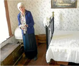  ??  ?? Margaret Gibson in one of the elaboratel­y decked out rooms in keeping with the cottage’s heritage.