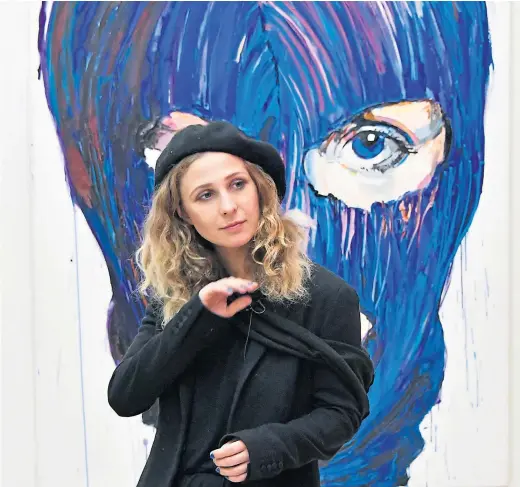  ?? Picture Nils Jorgensen ?? Pussy Riot’s Maria Alyokhina in front of painting of her wearing the band’s trademark balaclava at Saatchi Gallery, London in 2017