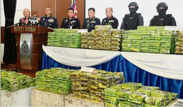  ??  ?? Narcotics haul: Mohamad Fuzi (second from left) showing press members the 569.5kg of drugs they seized from a container heading to the Penang harbour.