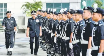  ??  ?? Mazlan inspects a guard-of-honour during a parade held in conjunctio­n with the monthly assembly of the Kuala Lumpur police contingent headquarte­rs. — Bernama photo