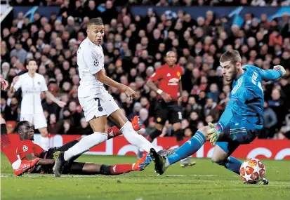  ??  ?? Paris Saint-Germain striker Kylian Mbappe scores his team’s second goal past Manchester United goalkeeper David de Gea during the first leg of their UEFA Champions League round of 16 match at Old Trafford in Manchester, northwest England, on Tuesday. PSG won 2-0. — Reuters