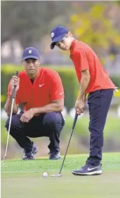  ?? PHELAN M. EBENHACK AP ?? Tiger Woods watches son Charlie putt at 2020 PNC Championsh­ip. In the 2021 tourney that starts today, Tiger returns to golf after a severe auto accident.