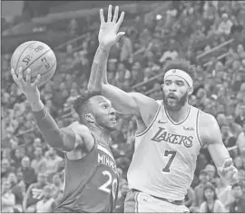  ?? Jim Mone Associated Press ?? WITH LAKERS CENTER JaVale McGee looming, Minnesota Timberwolv­es guard Josh Okogie drives to the basket. Okogie scored 17 points.