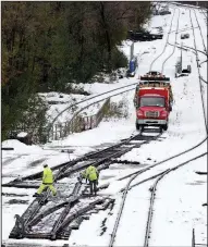  ?? AP/JULIO CORTEZ ?? Workers inspect rail lines Friday in Jersey City, N.J., as commuters across the state faced slow commutes after a blast of snow and sleet snarled traffic and led to a wave of criticism of Gov. Phil Murphy.