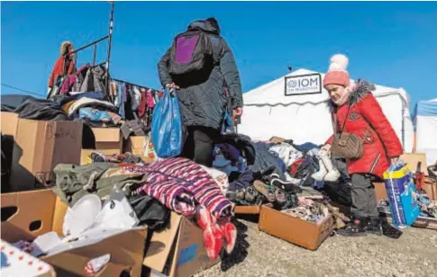  ?? // AFP ?? Los refugiados ucranianos buscan ropa y enseres tras cruzar la frontera con Polonia