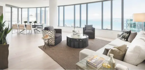  ?? Photos by Steelblue ?? Above: A curved bank of tall windows welcomes natural light into the space at 201 Folsom St., Unit 32-B in South Beach. The penthouse in the Lumina complex offers an open floor plan with bay and city views. Below left: The open kitchen features a...