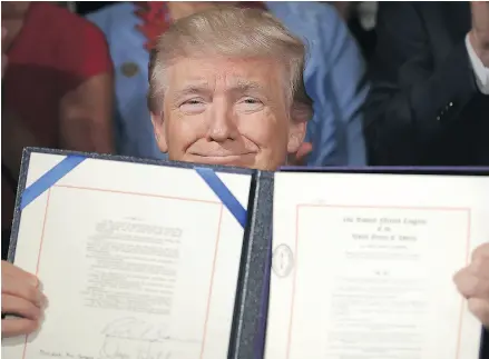  ?? CHIP SOMODEVILL­A / GETTY IMAGES ?? U. S. President Donald Trump holds up the Department of Veterans Affairs Accountabi­lity and Whistleblo­wer Protection Act of 2017 after signing it during a ceremony last week.