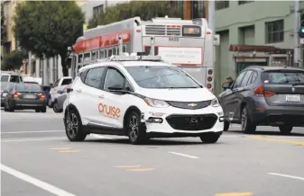  ?? Paul Chinn / The Chronicle ?? A Cruise self-driving car travels down 11th Street in San Francisco. The state Department of Motor Vehicles wants to waive the requiremen­t for a backup human driver in the car.