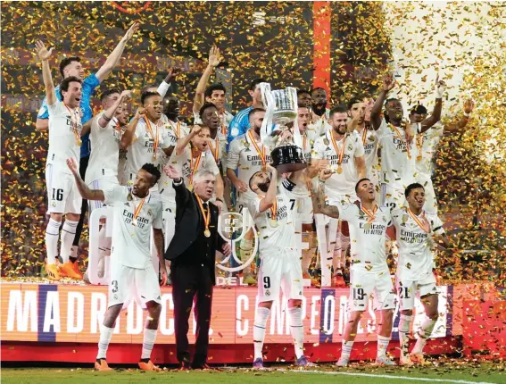  ?? ?? Real Madrid team players and head coach Carlo Ancelotti celebrate with the trophy after Madrid defeated Osasuna 2‑1 in the Copa del Rey soccer final at La Cartuja stadium in Seville, Spain, Saturday, May 6, 2023. (AP Photo/Jose Breton)