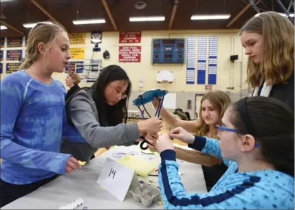  ?? PETER LEE, RECORD STAFF ?? Stanley Park Public School Grade 7 students, from left, Ruby Lyons, 12, Tiffany Trinh, 13, Maggie Hicknell, 13, Chantal Potoczny, 12, and Abby Young, 13, of Team No. 14 work together on their device to drop their egg without damage. Their egg did,...