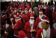  ?? (AP Photo/Eugene Hoshiko, File) ?? MIDDLE LEFT
Approximat­ely 200 local employees dressed in Santa Claus costumes parade in the festive atmosphere through the Marunouchi district in Tokyo, Friday, Dec. 22, 2017.