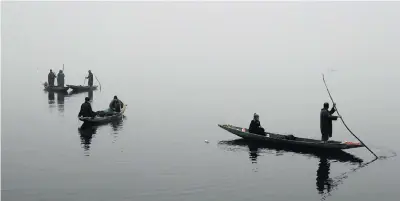  ?? Picture: EPA ?? Kashmiri labourers extract weeds from Dal Lake in Srinagar, the summer capital of Indian Kashmir, yesterday. Temperatur­es at night are below freezing point.