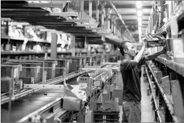  ?? GARY FRIEDMAN/LOS ANGELES TIMES 2014 ?? A worker fills an order for online retailer Newegg in City of Industry, Calif. Many sellers say it would be burdensome to collect taxes set by more than 12,000 jurisdicti­ons in the U.S.