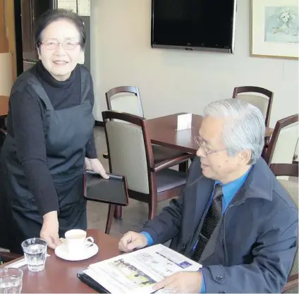  ?? ERIN ELLIS/ VANCOUVER SUN ?? Eiko Inouchi, 73, serves a cup of coffee to Seiichi Kimura of the University of Tokyo’s Institute of Gerontolog­y in the café of the Toyoshikid­ai Danchi apartment complex. Inouchi says she decided to work as a server several times a week so that she...