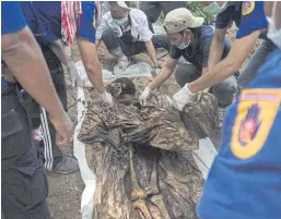  ??  ?? GRAVE NEWS: Rescue workers and forensic officials dig out a skeleton found at an abandoned jungle camp in the Sadao district of Songkhla.