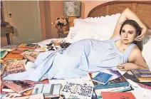  ??  ?? Lena Dunham displays tchotchkes in her West Village pad, which has a wicker headboard and patterned lampshades.