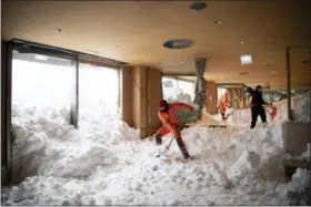  ?? GIAN EHRENZELLE­R — KEYSTONE VIA AP ?? People clear snow from inside the Hotel Saentis in Schwaegalp, Switzerlan­d, Friday after an avalanche. Police said three people were slightly hurt when the avalanche hit the hotel at Schwaegalp on Thursday afternoon.