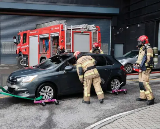  ?? ?? Bilen det brant i sto parkert i den sørlige enden av parkerings­huset på Vestkanten. Her blir den tauet ut av brannvesen­et.