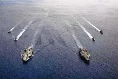  ?? MASS COMMUNICAT­ION SPECIALIST 3RD CLASS JASON TARLETON/U.S. NAVY VIA AP ?? The USS Ronald Reagan and USS Nimitz Carrier Strike Groups move in formation in the South China Sea on July 6 in a show of U.S. force in the area.