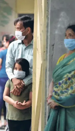  ??  ?? PEOPLE wait for their turn to give samples for COVID-19 test at a school in New Delhi on June 25.