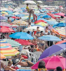  ??  ?? Sunbathers on the beach at Alicante had little room for manoeuvre