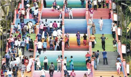  ??  ?? Local and foreign tourists walking up the steps of Batu Caves to reach the Sri Subramania­r Swamy temple.