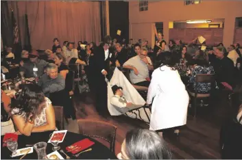  ?? SARINA E. GUERRA PHOTO ?? Attendees gasp at the sight of murder victim “Sal Fee” during a fundraiser dinner put on by Burning Bush Internatio­nal and American Immersion Theatre during BBI’s “The Billionair­e’s Club Masquerade Ball” murder mystery dinner-fundraiser on Thursday, October 12, at Stockmen’s Club of Imperial Valley, in Brawley.