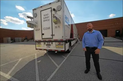  ?? PETE BANNAN – DIGITAL FIRST MEDIA ?? Chad Murnane, chief operating officer of ARRB Group, is shown outside the Intelligen­t Pavement Assessment Vehicle, which uses Doppler lasers to access pavement conditions. The rear includes cameras to record road conditions.