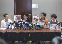  ?? —AFP ?? HONG KONG: Hong Kong pro-democracy legislator Nathan Law (centre L), along with Edward Yiu (L), Joshua Wong (centre R) and Eddie Chu (R), hold a press conference in which they show photos of injuries sustained to Nathan Law after he was attacked by...