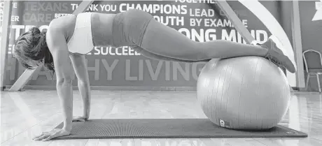  ?? Brett Coomer photos / Houston Chronicle ?? Morgan uses a balance ball to increase the range of her push-ups.