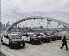  ?? Robert Gauthier Los Angeles Times ?? LAPD OFFICERS prepare to remove a bicycle club from the 6th Street Viaduct as part of a recent “traffic enforcemen­t operation.”