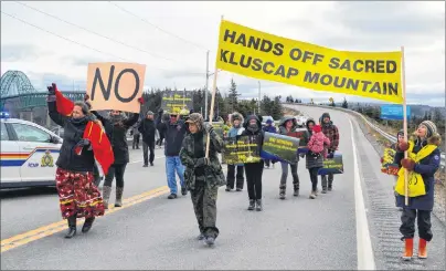  ?? JEREMY FRASER/CAPE BRETON POST ?? Protesters march near Seal Island Bridge in Victoria County on Saturday as part of a rally against mining on Kluscap Mountain and other protected areas in Nova Scotia. About 40 people attended the rally, which caused traffic disruption­s for about an...