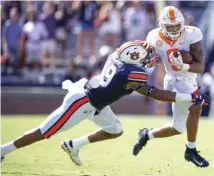  ?? PHOTO BY PATRICK MURPHY-RACEY ?? Tennessee running back Tim Jordan heads for the sideline as Auburn linebacker Darrell Williams tries to wrap up during last Saturday’s game at Auburn. The Vols averaged 1.9 rushing yards per carry against the Tigers but won the game 30-24.