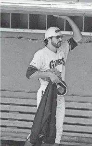  ?? [AP FILE PHOTO] ?? San Francisco Giants pitcher Steve Bedrosian wears a constructi­on worker’s hard hat Oct. 19, 1989, as he “holds up the roof” of the Giants dugout during the Giants workout at Candlestic­k Park in San Francisco. It was their first workout after an...