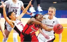  ??  ?? Arizona guard Aari McDonald (2) passes between Stanford guard Anna Wilson, left, and forward Cameron Brink, right, during the second half of Sunday’s game.