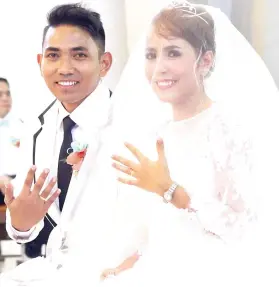  ?? / TAMPO ?? ■ KASAL NAMI: Mipakita sa ilang tagsatagsa ka wedding ring ang bag-ong kinasal nga sila si PO2 Ryan Christophe­r Morales ug Maria Luna Anga-Morales atol sa seremonyas sa ilang kasal niadtong Hunyo 16, 2018 sa Sacred Heart Parish, siyudad sa Sugbo.