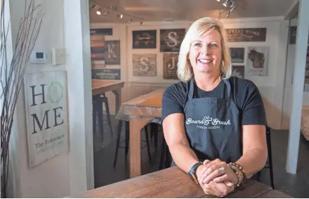 ?? MARK HOFFMAN / MILWAUKEE JOURNAL SENTINEL ?? Julie Selby owns a franchisin­g company that has grown rapidly. Board and Brush has studios where people make home-decor items while drinking wine and beer. Selby started with one studio in Hartland in January 2015. She now has 161 open, and another 40 or so under contract to open soon.