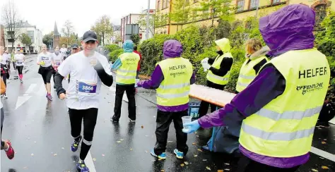  ?? BILD: PIET MEYER ?? Sie können jedem das Wasser reichen: Unter anderem an den Getränkest­änden sind die ehrenamtli­chen Helfer während des Marathons im Einsatz. Aber auch an vielen anderen Stellen werden sie gebraucht.