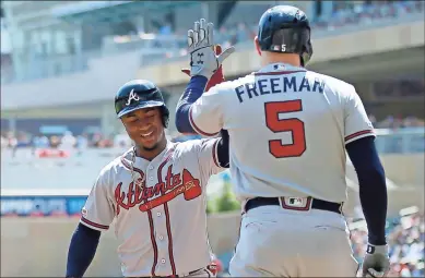  ?? AP - Jim Mone ?? Ozzie Albies, left, gets a high-five from Freddie Freeman after hitting a home run in the first inning of Wednesday’s game. Freeman hit a homer of his own in the next at-bat.