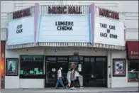  ?? DAMIAN DOVARGANES / ASSOCIATED PRESS ?? A family wears masks as they walk past the Lumiere Cinema at the Music Hall in Beverly Hills, California, on April 15.