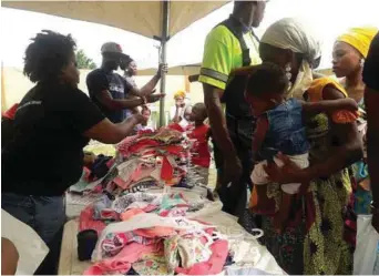  ??  ?? Giving out babies clothes to mothers