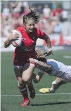  ??  ?? Canada’s Ashley Steacy carries the ball past an England tackler during quarter-final action. Canada won 33-5.