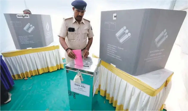  ?? Associated Press ?? ↑
A policeman on election duty, casts his postal ballot vote ahead of the upcoming Gujarat state assembly elections in Ahmedabad, on Friday.