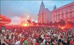  ?? AP ?? ■
Liverpool FC fans ignite flares outside the Liver Building in Liverpool as they celebrate the team’s English Premier League title on Friday.